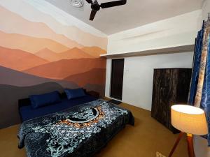 ein Schlafzimmer mit einem Bett mit einem Wandbild der Berge in der Unterkunft Wild Mountain Homestay in Rishikesh