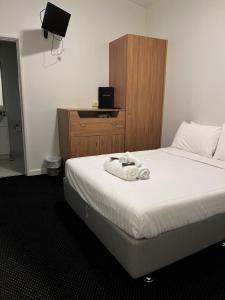 a bedroom with a bed with a wooden headboard at Star Bar Cafe & Hotel in Launceston