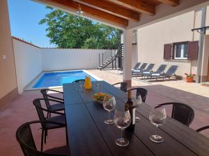 a dining table with wine glasses on a patio at Holiday House Teza in Svetvinčenat