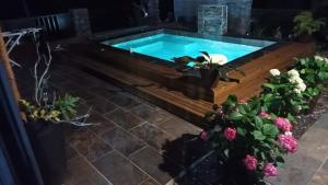a swimming pool in a garden with flowers at LA VIE LA Bien Être GG in Le Tampon