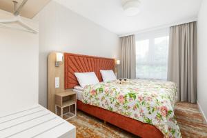 a hotel room with a bed and a window at Sun & Beach Apartments Bel Mare with Parking by Renters in Międzyzdroje