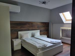 a bedroom with a bed with a wooden headboard at The old Bakery Apartments in Plovdiv