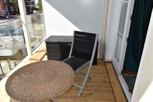 einen Stuhl, einen Schreibtisch und einen Tisch auf dem Balkon in der Unterkunft Villa Seestern Ferienwohnung Nr 03 in Niendorf