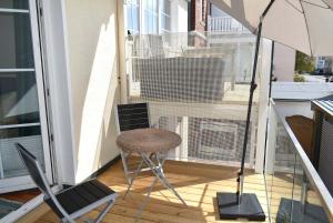 einen Balkon mit einem Tisch, einem Stuhl und einem Sonnenschirm in der Unterkunft Villa Seestern Ferienwohnung Nr 03 in Niendorf