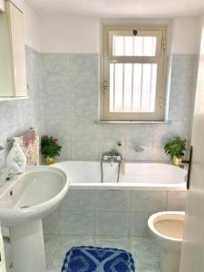 een badkamer met een bad, een wastafel en een toilet bij Casa Vacanze EtnaMolù in Giarre