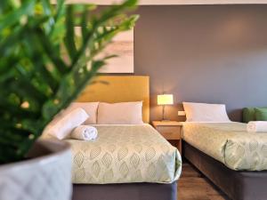 Apollo Bay的住宿－海景旅館公寓，一间酒店客房,配有两张床和植物