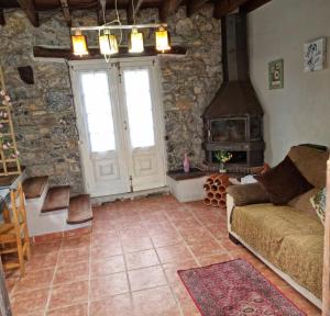 sala de estar con sofá y estufa de leña en Corias Casona junto al Narcea en Corias