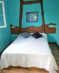 een slaapkamer met een groot wit bed met blauwe muren bij Corias Casona junto al Narcea in Corias