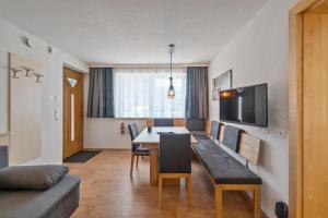 a living room with a dining table and a tv at Haus Aventurin in Fiss