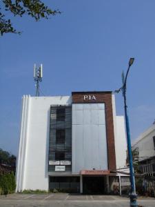 un gran edificio blanco con un cartel de pizza en Pia Hotel, en Cirebon