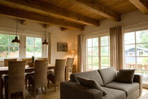 sala de estar con sofá y mesa con sillas en Ruhiges Landhaus Krienke - Doppelhaus mit Sauna & Kamin, en Rankwitz
