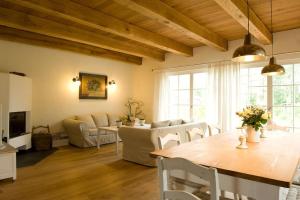 sala de estar con mesa, sillas y sofá en Ruhiges Landhaus Krienke - Doppelhaus mit Sauna & Kamin, en Rankwitz