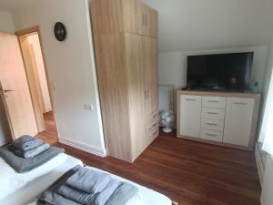1 dormitorio con 1 cama, TV y armario en Ferienhaus in der Schleife 1, en Rendsburg