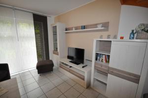 een woonkamer met een flatscreen-tv en een stoel bij Nr 42 - Ferienhaus Im Groden Nähe Kurzentrum in Carolinensiel