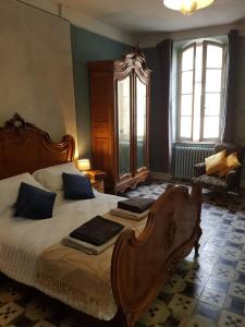 um quarto com uma grande cama de madeira com almofadas azuis em La Scierie em Quillan