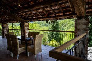 a patio with a table and chairs on a balcony at IDUEVAGAMONDI di Simone Mondino in Chiusa di Pesio