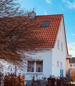 uma casa branca com um telhado vermelho em Lütje Perle em Wunstorf