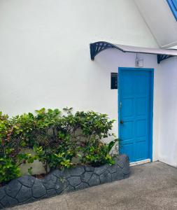 una puerta azul en el lateral de un edificio blanco en Sunset Seaview Patong en Patong Beach