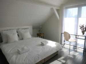 a bedroom with a white bed with two towels on it at Małe Letnisko in Puck