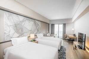 上海的住宿－长河国际公寓新天地，酒店客房设有两张床,墙上挂有绘画作品