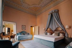 a bedroom with a bed and a couch and a table at Loggiato Dei Serviti in Florence