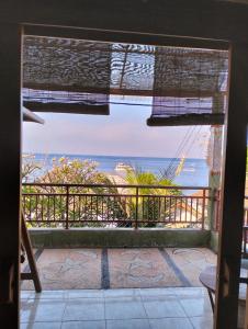 a room with a view of the ocean from a balcony at Dharma Yoga Homestay dan hostel in Amed