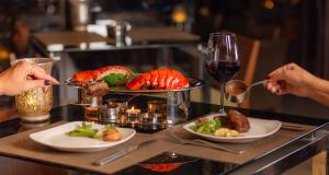 a table with a plate of food and a glass of wine at Marassi Marina in El Alamein