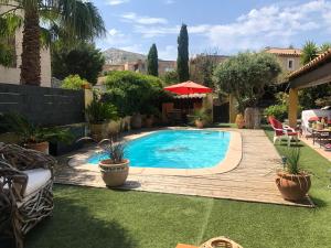 a swimming pool in a yard with a wooden deck at chez Guy in Marseille