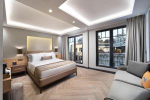 ein Schlafzimmer mit einem Bett, einem Sofa und Fenstern in der Unterkunft Motto By Mula Hotel in Istanbul