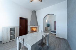 a dining room with a white table and a fireplace at Casa vacanze Petra in Squinzano