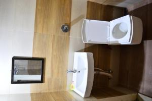 a bathroom with a white toilet and a mirror at Hotel Bholenath Palace in Ujjain