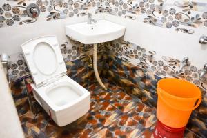 a bathroom with a toilet and a sink at Hotel Bholenath Palace in Ujjain