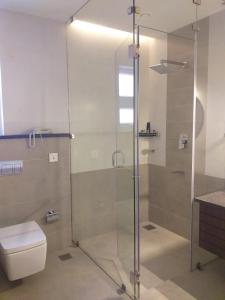 a bathroom with a glass shower with a toilet at Woodbine Foliage in Malappuram