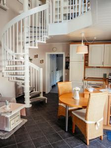 a kitchen and dining room with a spiral staircase at Komfortferienwohnung mit traumhaftem Moselblick in Sankt Aldegund