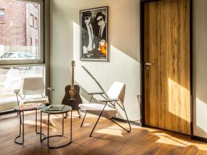 Habitación con sillas, guitarra y puerta en ibis Hotel Dortmund City, en Dortmund