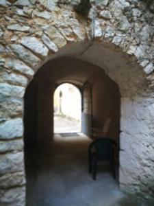 un arco en una pared de piedra con una silla en La Casa nell’Antico Borgo, en Alvito