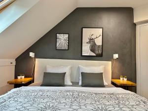a bedroom with a bed with three pictures on the wall at Molinaro Apartmány Jeseníky in Karlovice