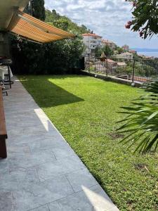 a garden with a grassy yard with a wooden roof at Eagle's Nest in Rijeka