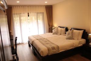 Un dormitorio con una cama grande con una ventana grande. en Le Baan Thai Boutique Villa, en Chiang Mai 30 fotos más