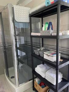 a black shelving unit in a bathroom with towels at Eagle's Nest in Rijeka