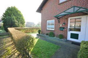 a brick house with a white door and a yard at Nr 52 - Ferienhaus Marie-Ulfers-Weg in Carolinensiel