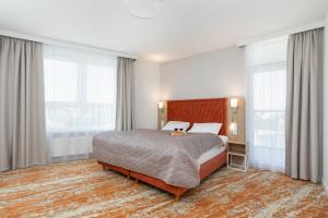1 dormitorio con 1 cama grande y ventanas grandes en Sun & Beach Apartments Bel Mare with Parking by Renters, en Międzyzdroje