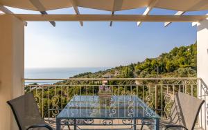 a table on a balcony with a view of the ocean at Sun And Stone in Athani