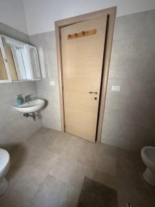 baño con aseo, lavabo y puerta en Casa Giuliana, en Montesilvano