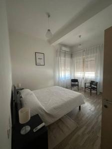 1 dormitorio blanco con 1 cama, mesa y sillas en Casa Giuliana, en Montesilvano