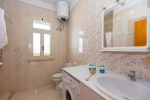 a bathroom with a sink and a toilet and a mirror at L'isola di Gianni by Ortigia Apartments in Plemmirio
