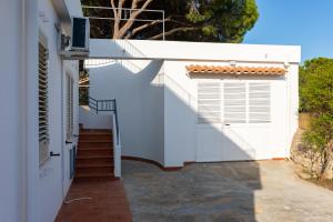 a white house with a staircase and a gate at L'isola di Gianni by Ortigia Apartments in Plemmirio