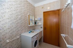 a bathroom with a washing machine and a sink at L'isola di Gianni by Ortigia Apartments in Plemmirio