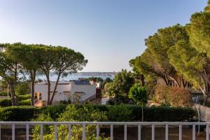 a view of a house with trees and a fence at L'isola di Gianni by Ortigia Apartments in Plemmirio