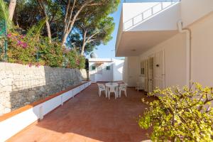 a patio of a house with a table and chairs at L'isola di Gianni by Ortigia Apartments in Plemmirio
